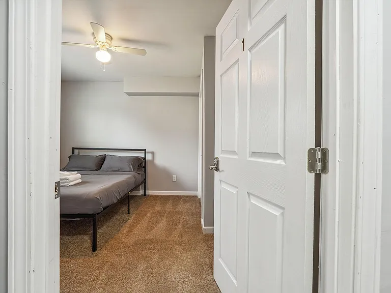 Private bedroom with a full-size bed, carpeted flooring, and a ceiling fan for added comfort.