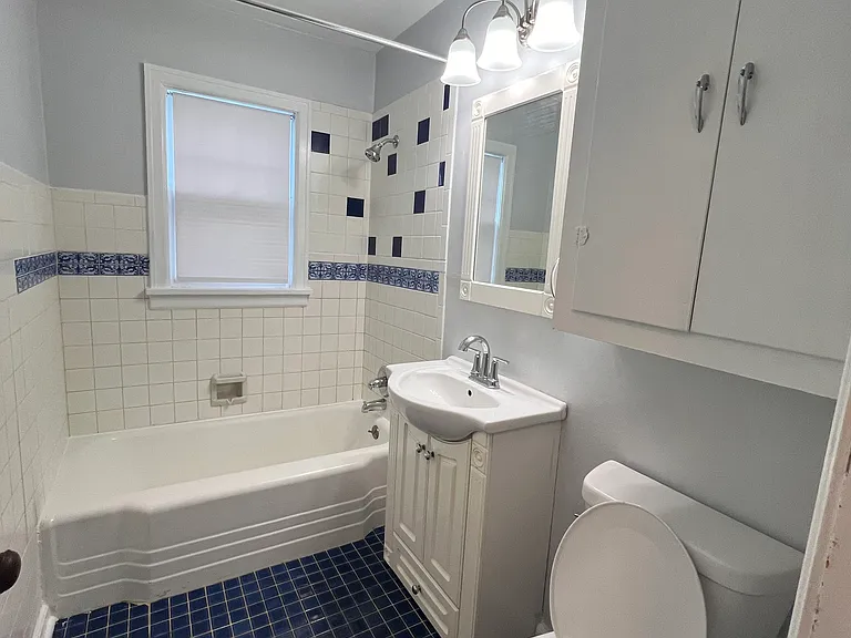 Newly updated bathroom with new toilet, sink, tub & shower hardware, and vanity light.
