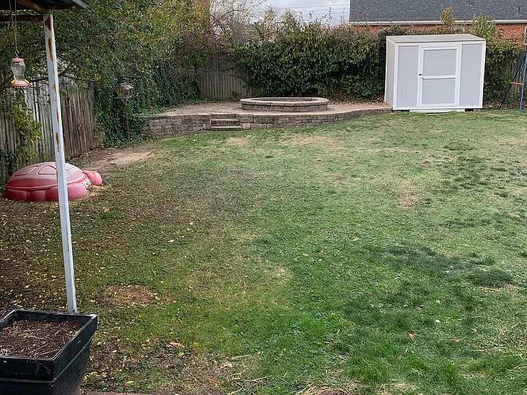Back yard raised patio with fire pit area (two sheds, raised garden, six foot privacy fence)
