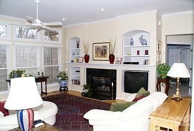 The expansive Great Room includes a wall of windows w/transoms that overlooks mature trees and priva