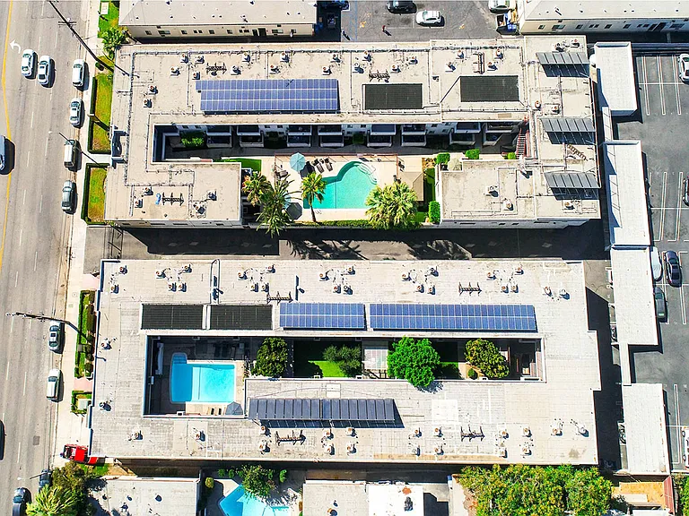 Aerial drone image of Sherman Oaks Gardens, showing solar panels and energy-efficient white roof.