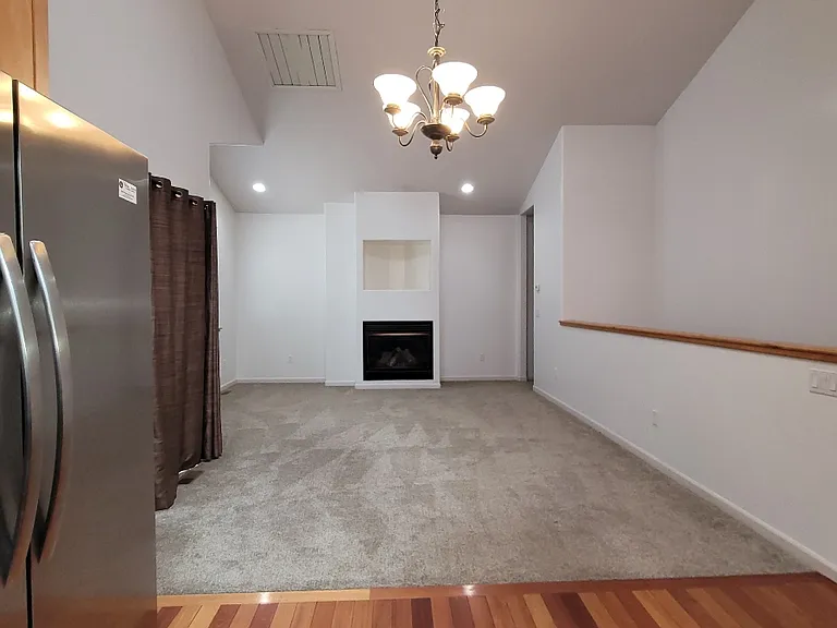 Looking to primary bedroom hall by the fireplace from the kitchen
