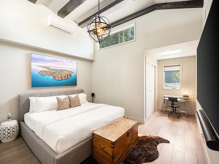 Boasting tall ceilings, the bedroom combines comfort and style for a truly luxurious retreat.
