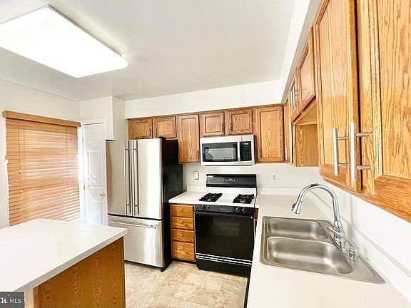 Kitchen view of appliances, gas stove, fridge with icemaker and water dispenser inside, microwave