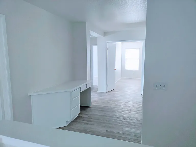 Upstairs hallway with view into primary bedroom