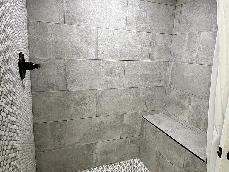 Shower space, with built in seat and sleek tile design