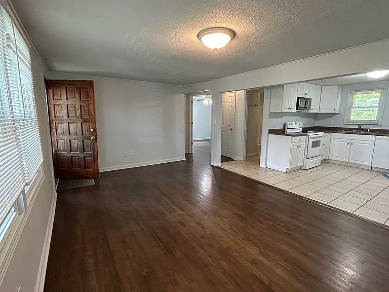 Front door opens into living room and kitchen, with bathroom, bedrooms, and storage to the left.