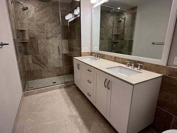 Modern bathroom with double sinks and dual shower head options.
