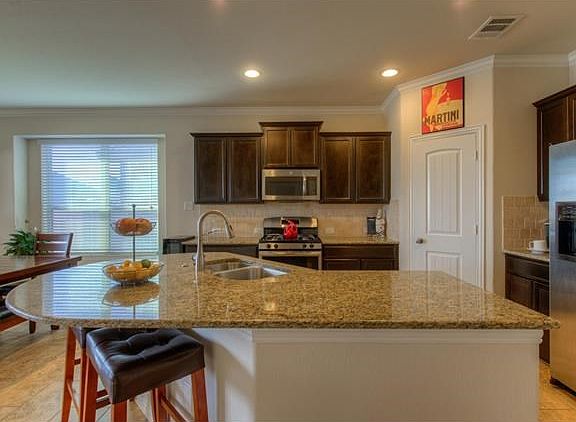 The kitchen offers a beautiful granite island and countertops, Energy Star appliances and rich, dark cabinetry.