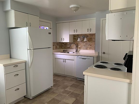 Kitchen with newer refrigerator, stove, dishwasher and over stove microwave oven.