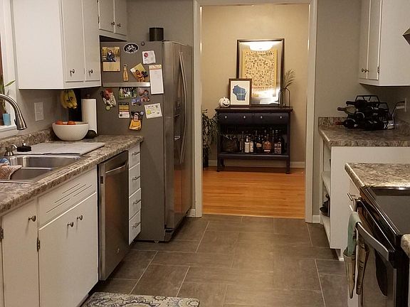 Newly updated kitchen with stainless steel appliances, ample storage including pantry, and balcony access