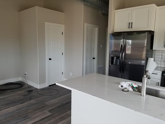 view from living room, coat/storage closet on left, then utility/furnace, then hallway that leads to bedroom/bath/laundry