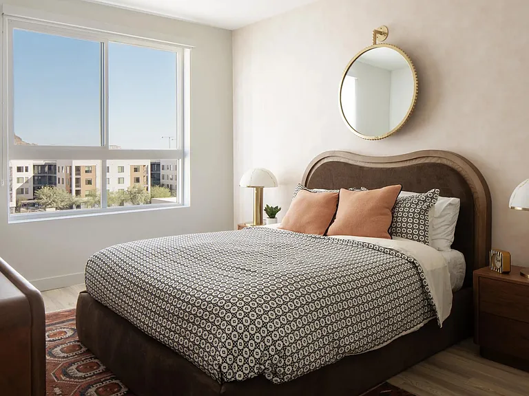 A serene bedroom retreat with warm textures, designer lighting, and natural light pouring in from expansive windows.