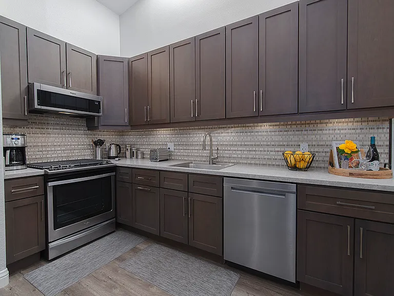 Full kitchen with coffee maker, hot tea pot, cooking utensils, and cook wear, including pots and pans.