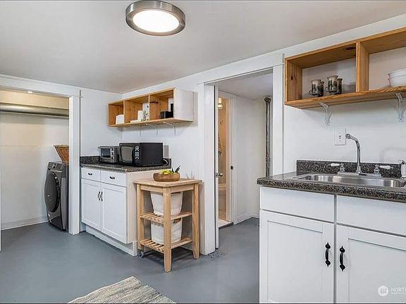 Kitchen complete with range, microwave, large sink, refrigerator, and washer/dryer.