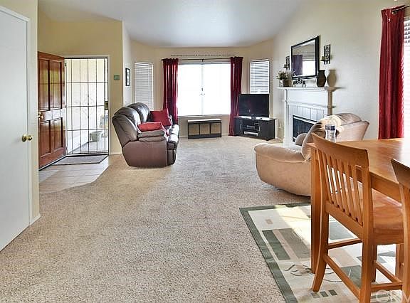 Living room with cozy fireplace and dining area. Lots of natural light!