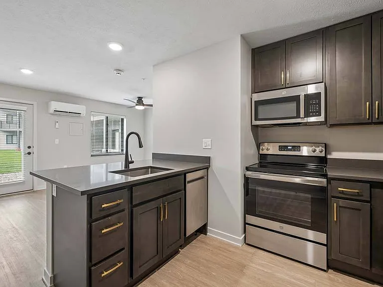 The stylish kitchen features sleek cabinetry, stainless steel appliances, and a spacious island perfect for gathering and everyday convenience.