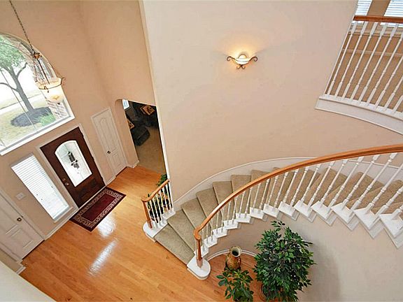 Striking entry with spiral staircase and hardwood floors.