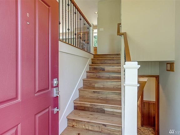 Beautiful arrival with custom entry banister blending wood & iron details.