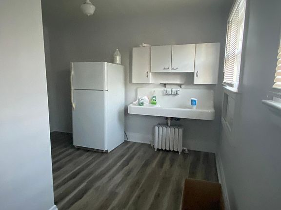 Kitchen facing from where kitchen table would be. Note new flooring in kitchen. Reglazed sink. Looks brand new.