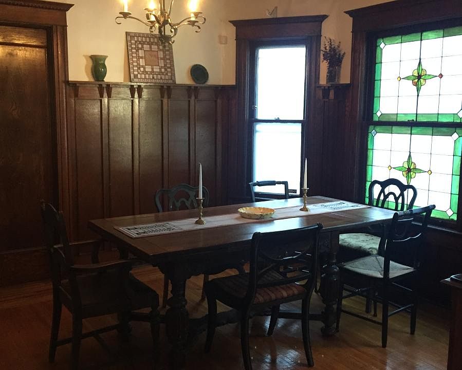 Gorgeous dining room with original wainscoting and stained g