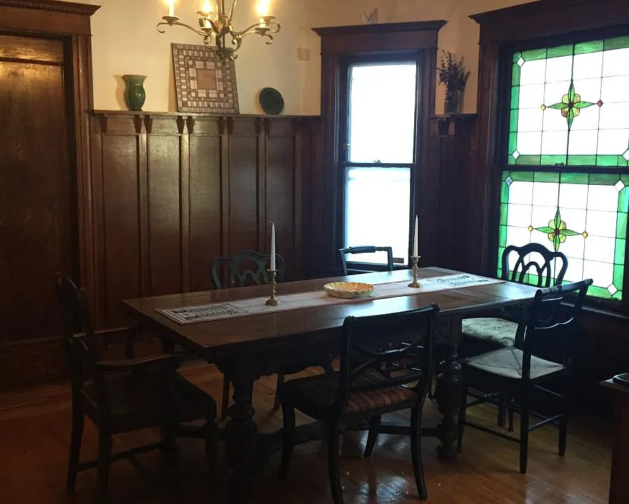 Gorgeous dining room with original wainscoting and stained g