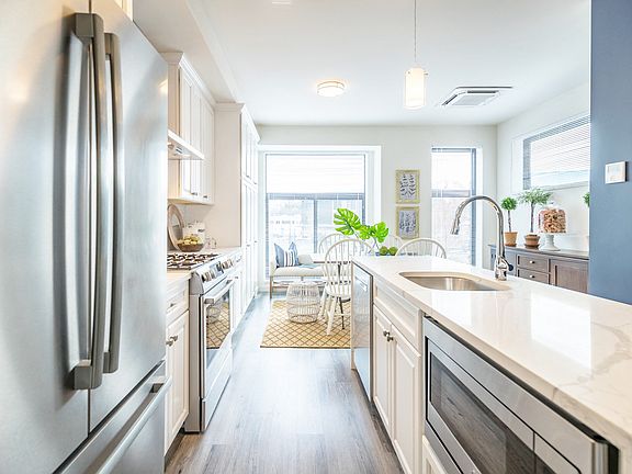 White Cabinets with brushed nickel pulls and Stainless Steel Appliance Package