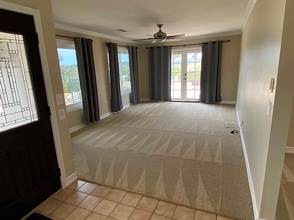 Carpet is replaced with VPL flooring. Entryway looking into the living room with double doors opening to the outdoor entertainment area