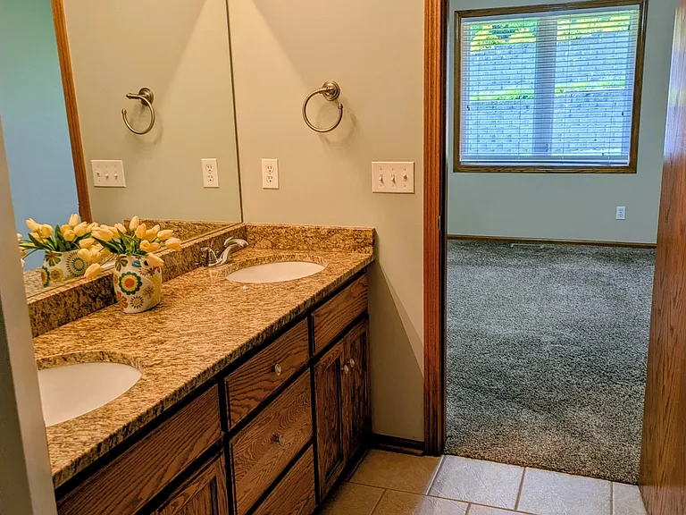 Primary bath with double vanity, jetted tub, shower, and private toilet room.
