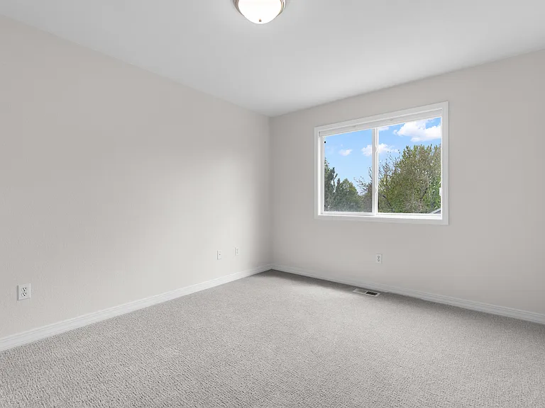 The second bedroom overlooks the backyard and features updated carpet, a spacious closet, and plenty of natural light.