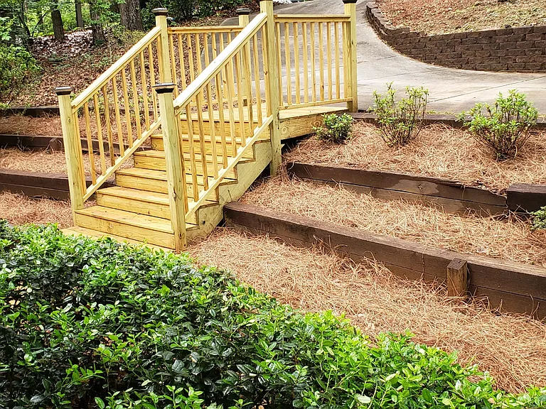 The new azaleas poking out of the pine straw will take time to mature, but they will blossom red and white (or so the landscaper says!).