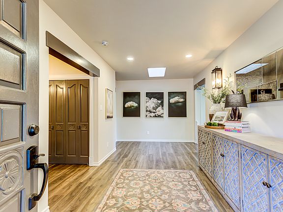 Welcoming entry with a convenient coat closet and nearby guest bath, opening into the spacious living room and the open kitchen/dining area_perfect for everyday living and entertaining.