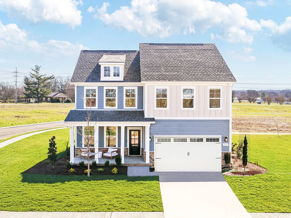 Home exterior with blue siding and white accents and covered front porch