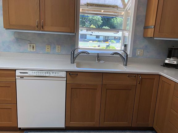 Kitchen faces street; Dishwasher, Corian counters & sink & 2 faucets.