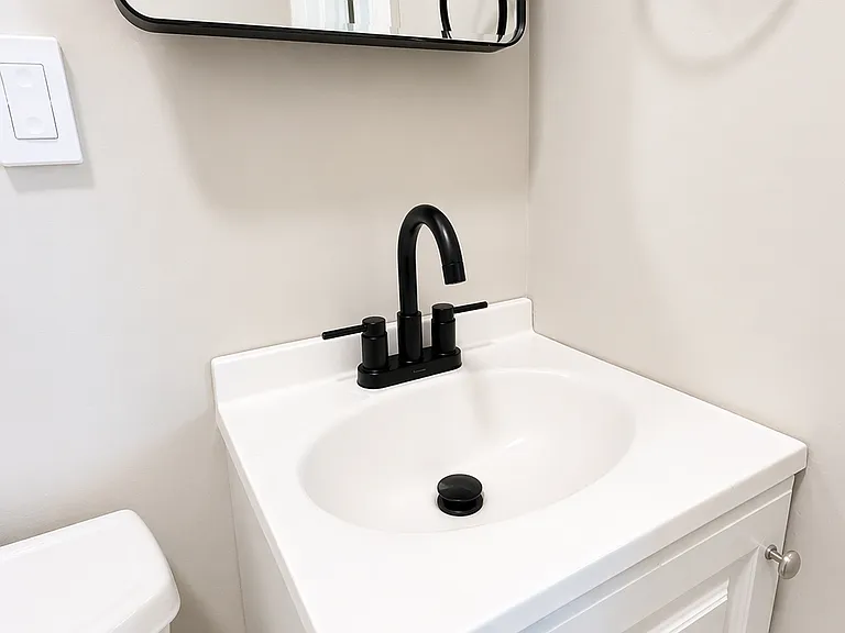 Refreshed bathroom with new fixtures, cabinets, mirror, faucet, hardware, paint.