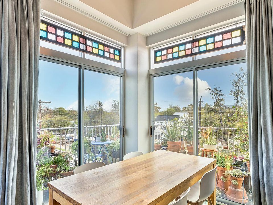 Wraparound top-floor balcony with custom drapes and vintage colored glass window decor.