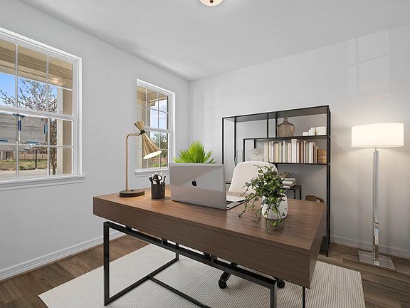 The home office features French doors, beautiful floors, large windows that give a fresh feel, this
