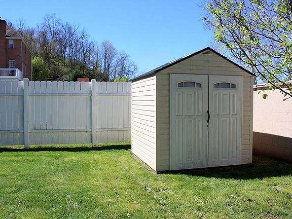 Fenced-in backyard provides privacy and includes storage building.