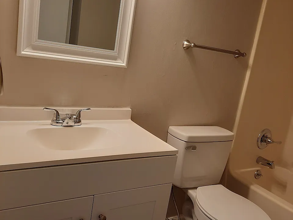 1 bedroom bathroom with light gray vanity and gray VCT flooring