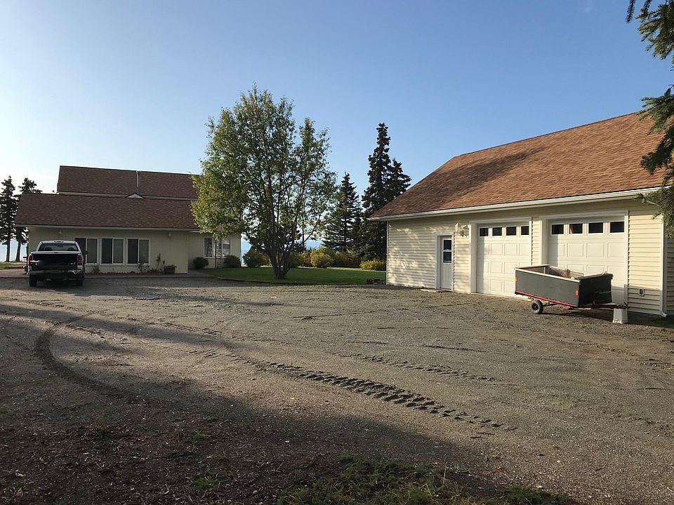 View West from driveway/parking toward house (Inlet beyond); garage at right.