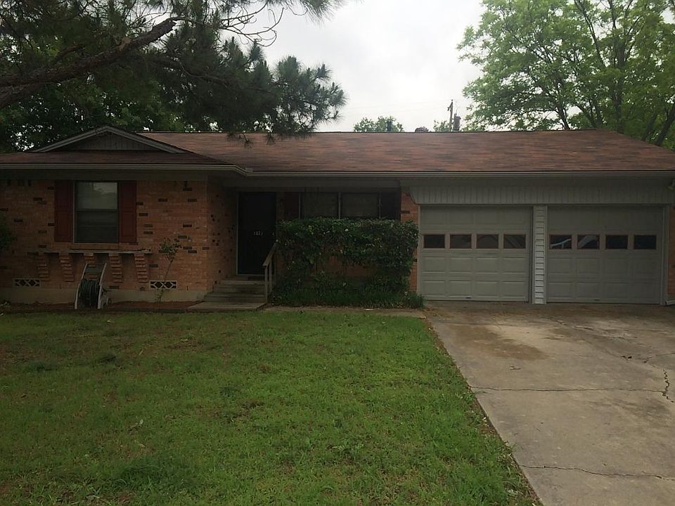 Front Yard with large Pine tree and two car garage with Washer Dryer connections.