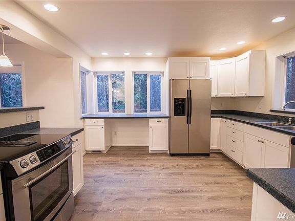 Large kitchen with solid surface countertops, laminate floors and stainless steel appliances. 