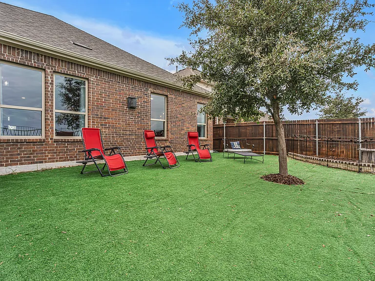 Backyard with artificial turf (green year-round). Enjoy outdoor seating with beautiful sunsets and lake views