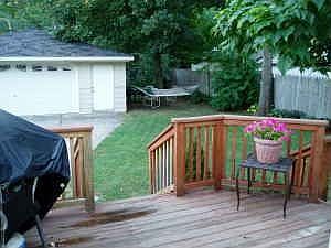 Deck, 2+ car garage and green lawn