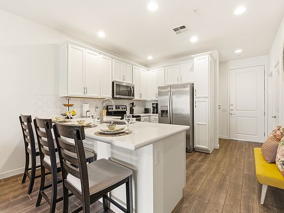 Modern, fully equipped kitchen with quartz countertops and stainless-steel appliances.
