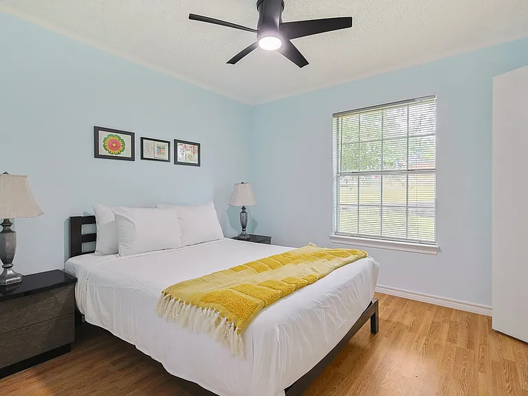 Bedroom 2 - a queen bed with a large window allowing lots of light into the room.