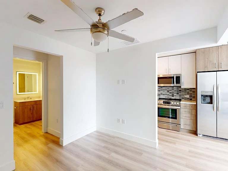 Spacious apartment Bedroom with Attached Bathroom and wood-panel flooring.