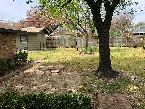 Large fenced back yard with mature trees.