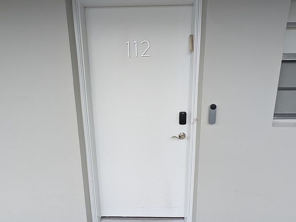 Entrance to unit 112 in Camelia 112. Smart home features Google Doorbell and Yale Lock.