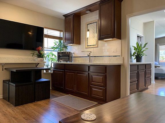 Sitting on couch looking at kitchen, TV and dinning table.